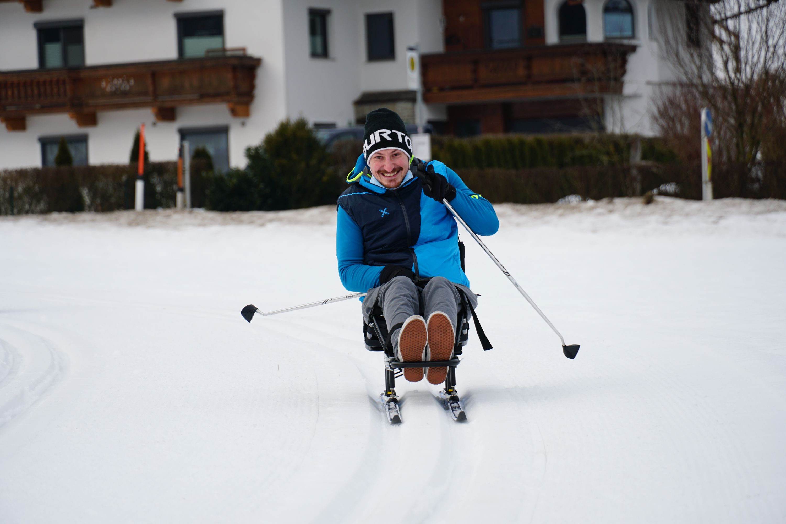 Mit Hilfe eines Langlaufschlittens, bei dem ein Sitz auf zwei Skiern montiert ist, können sich Menschen im Rollstuhl auf den Loipen fortbewegen.