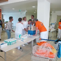 Mehrere Mitarbeiterinnen und Mitarbeiter probieren die Händedesinfektion unter Kontrolle in der Didakto-Box aus.