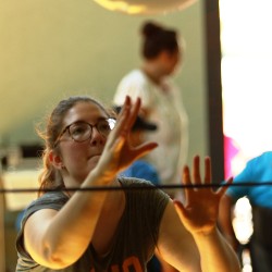 Eine Teilnehmerin spielt sehr konzentriert einen Wasserball über die Schnur zu ihrer Partnerin.