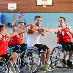 Ein leidenschaftlicher Kampf eines Rollstuhlfahrers um den Basketball  gegen drei gegnerische Spieler der anderen Mannschaft. Foto von Werner Schorp