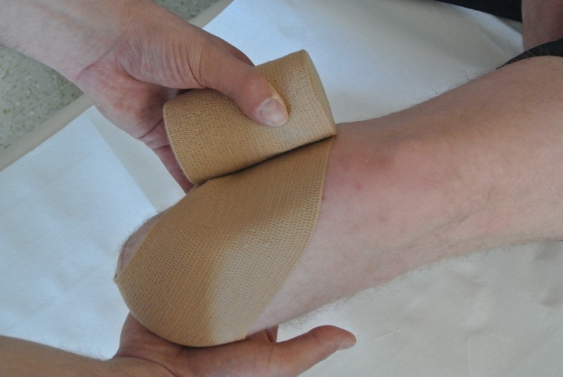 Anlage der Bandage durch eine Hilfsperson
