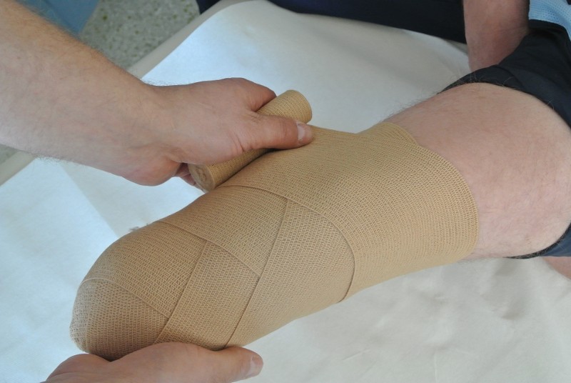 Anlage der Bandage durch eine Hilfsperson