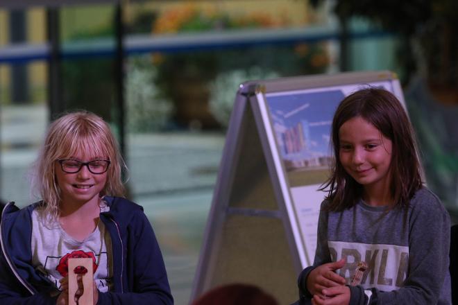 Malwettbewerb: Die beiden jungen Künstlerinnen Ronja Lettenbichler als Zeitplatzierte links und rechts Gewinnerin Linda Edenhauser. Lindas Bild wird das SCI-Day Logo 2020. Beide Mädchen schmunzeln und halten ihre überreichten Trophäen fest in den Händen.